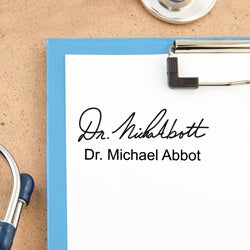close up of a doctor’s signature stamp impression on a white paper on a black clipboard