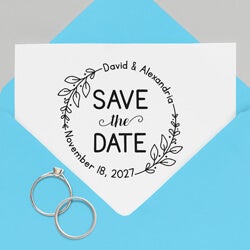a save the date wedding stamp impression on a white paper inside a gray envelope